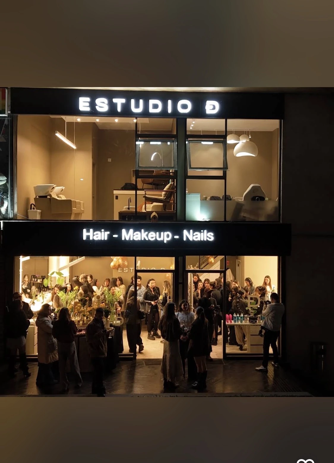 Fachada de Estudio D de noche con su letrero iluminado